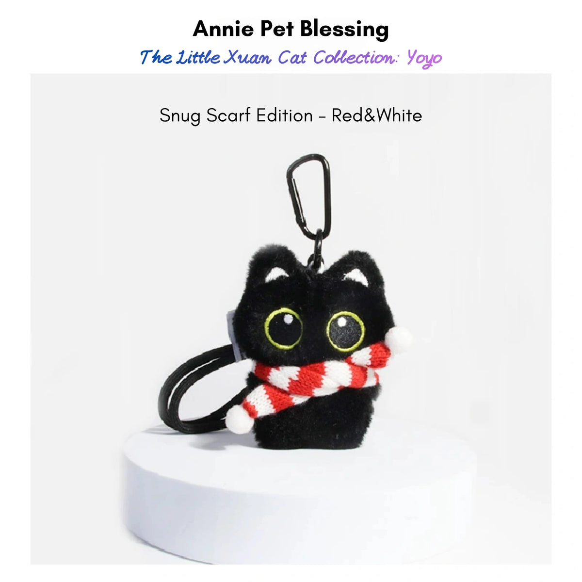 Black plush Yoyo keychain wearing a red-and-white striped knitted scarf with pom-poms