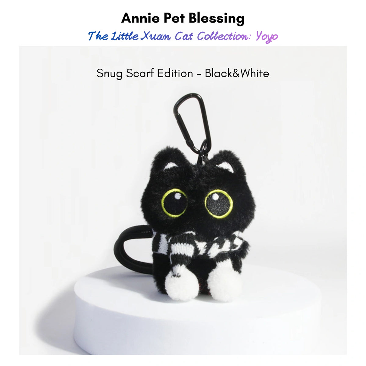 Black plush Yoyo keychain wearing a black-and-white striped knitted scarf with pom-poms