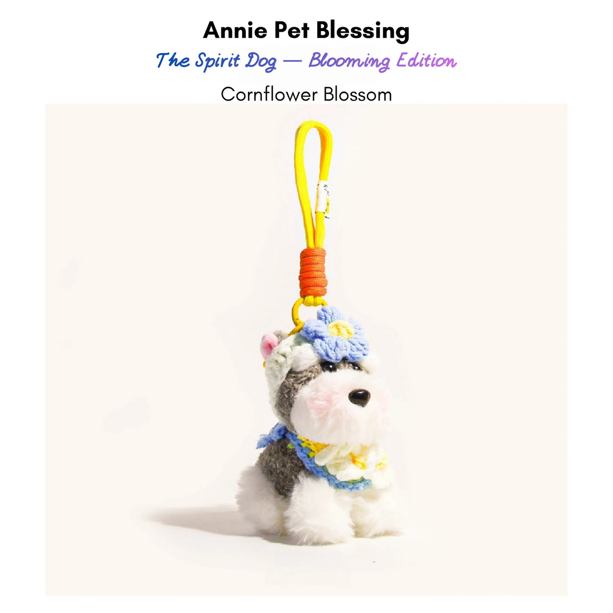 Grey-and-white plush Spirit Dog keychain wearing a blue crocheted flower and collar, Cornflower Blossom edition