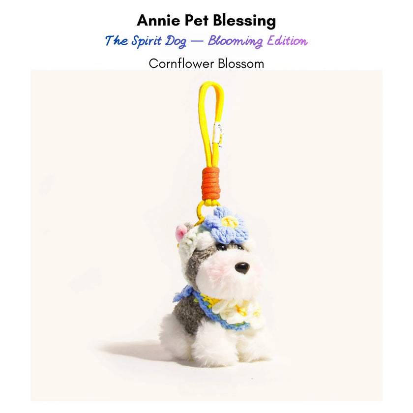 Grey-and-white plush Spirit Dog keychain wearing a blue crocheted flower and collar, Cornflower Blossom edition