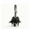 Close-up of a black plush bat-winged Yoyo keychain wearing goggles and a black-and-white striped scarf