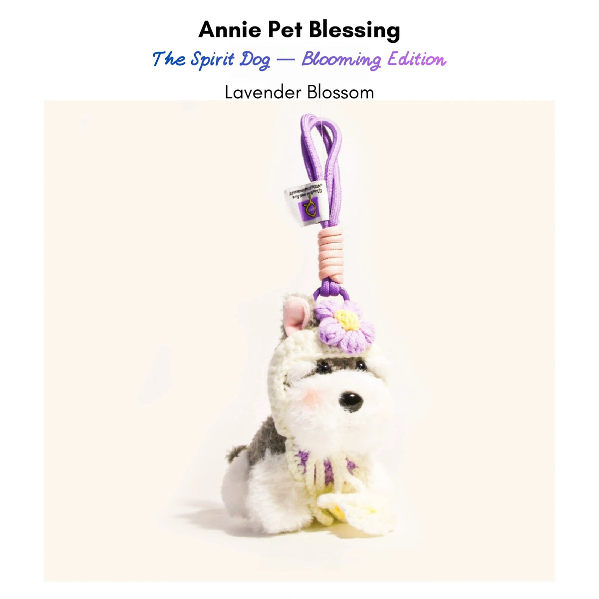 Grey-and-white plush Spirit Dog keychain wearing a lavender crocheted flower and collar, Lavender Blossom edition