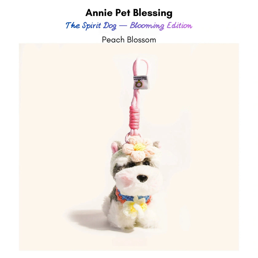 Grey-and-white plush Spirit Dog keychain wearing a peach crocheted flower and collar, Peach Blossom edition