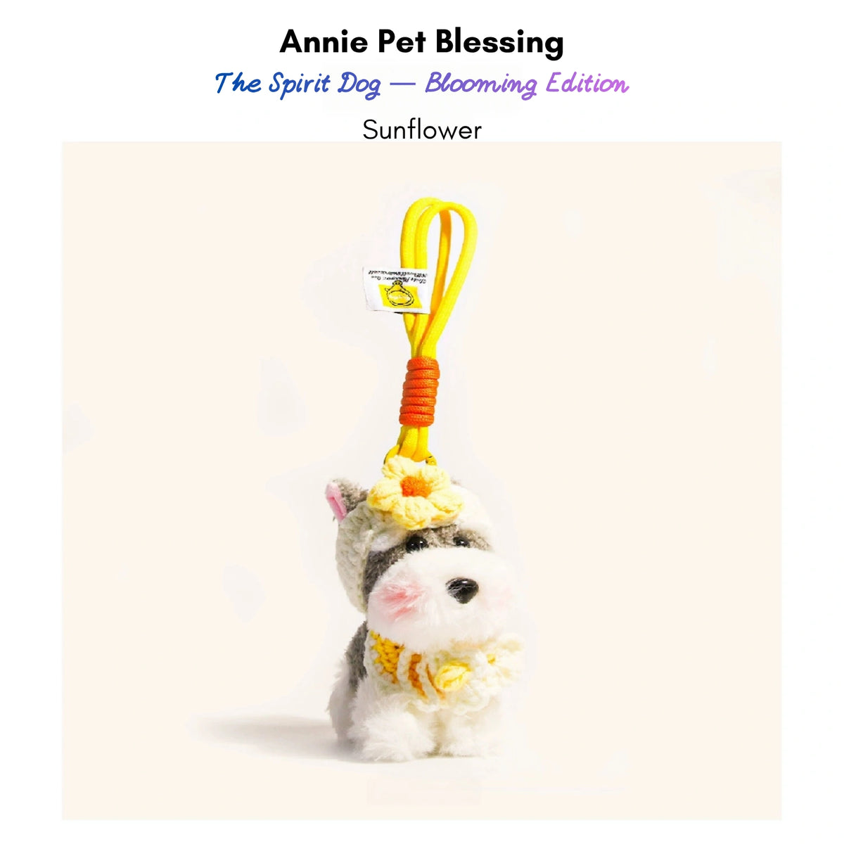 Grey-and-white plush Spirit Dog keychain wearing a yellow crocheted flower and collar, Sunflower edition