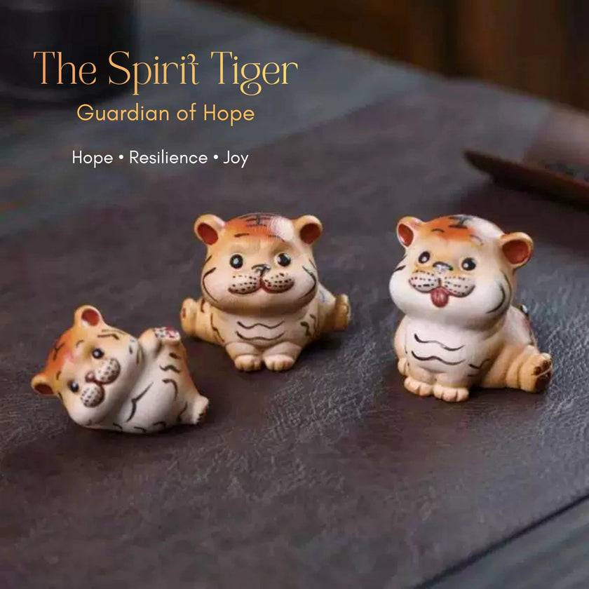 Three ceramic Spirit Tiger cub figurines in orange, cream, and black striped coloring in different poses