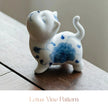 Close-up of a white ceramic Spirit Cat figurine with a blue lotus vine pattern