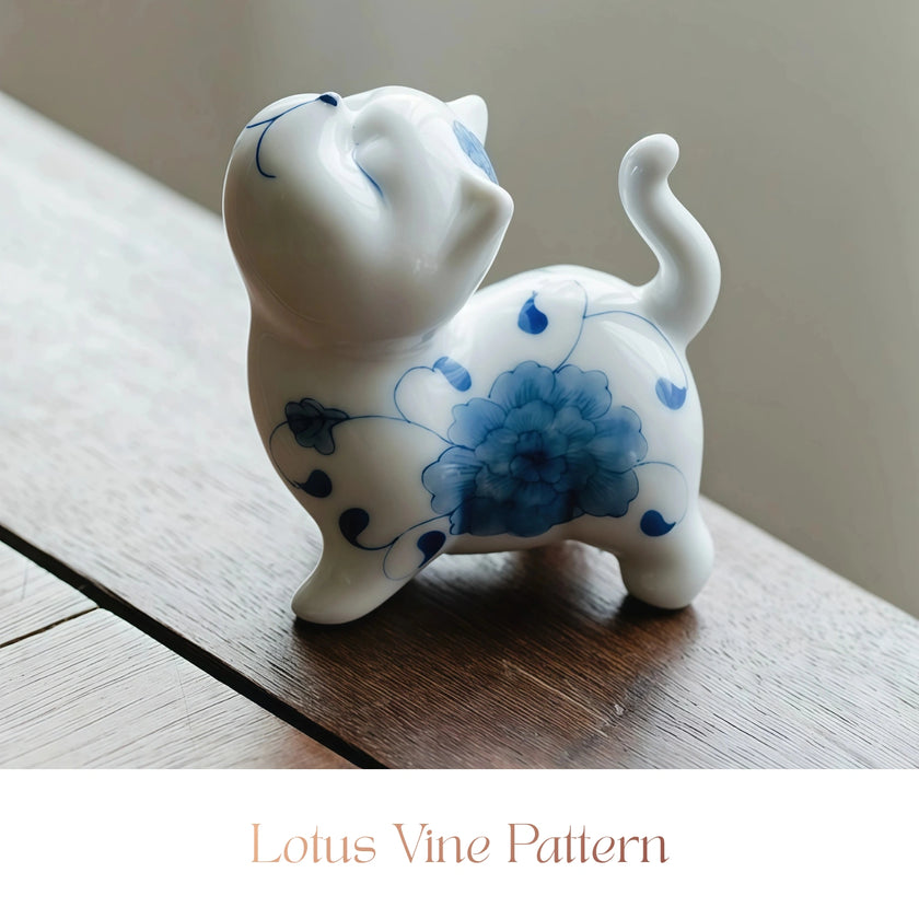 Close-up of a white ceramic Spirit Cat figurine with a blue lotus vine pattern