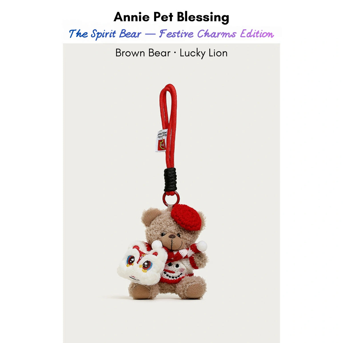 Brown plush Spirit Bear keychain wearing a red beret and scarf, holding a Lucky Lion charm
