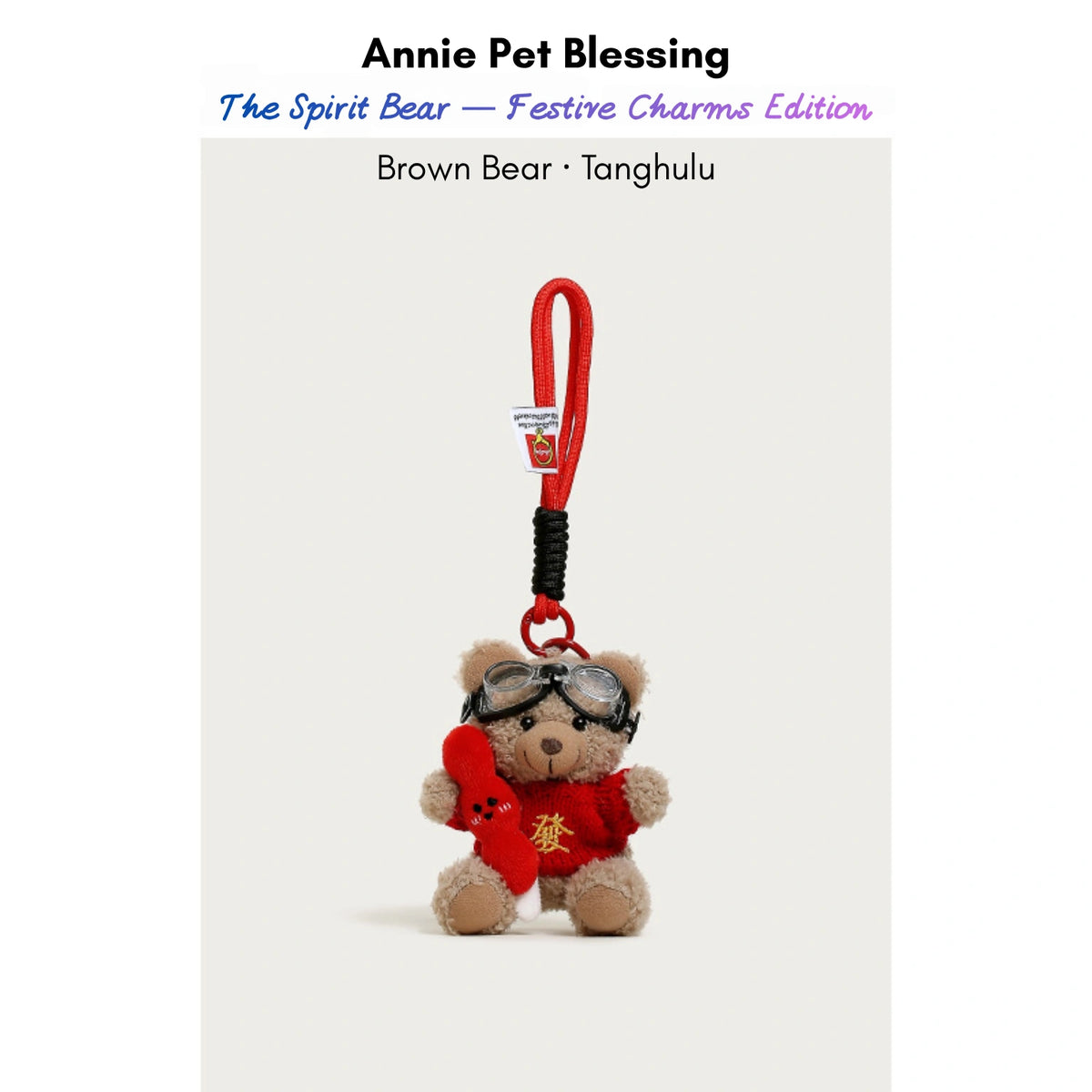 Brown plush Spirit Bear keychain wearing goggles and a red sweater, holding a Tanghulu charm