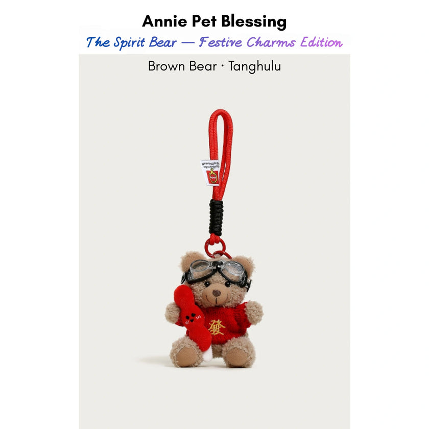 Brown plush Spirit Bear keychain wearing goggles and a red sweater, holding a Tanghulu charm