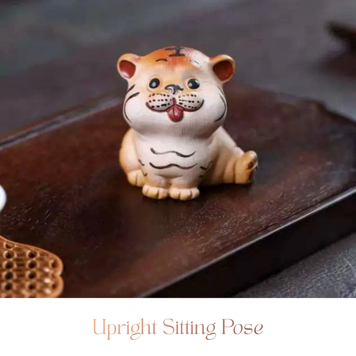 Close-up of a ceramic Spirit Tiger cub figurine sitting upright with its tongue out