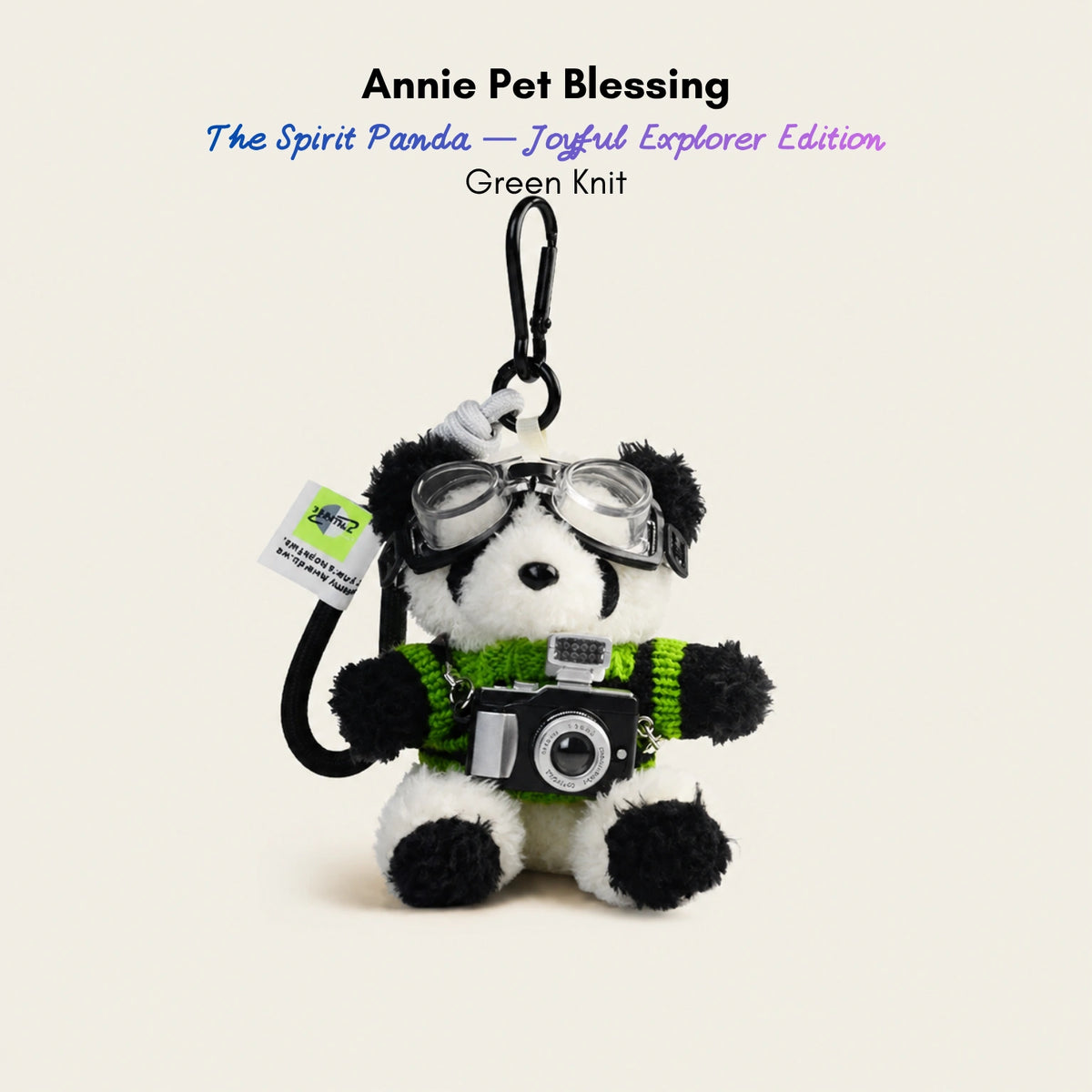 Plush Spirit Panda keychain wearing goggles and a green knit sweater, holding a toy camera