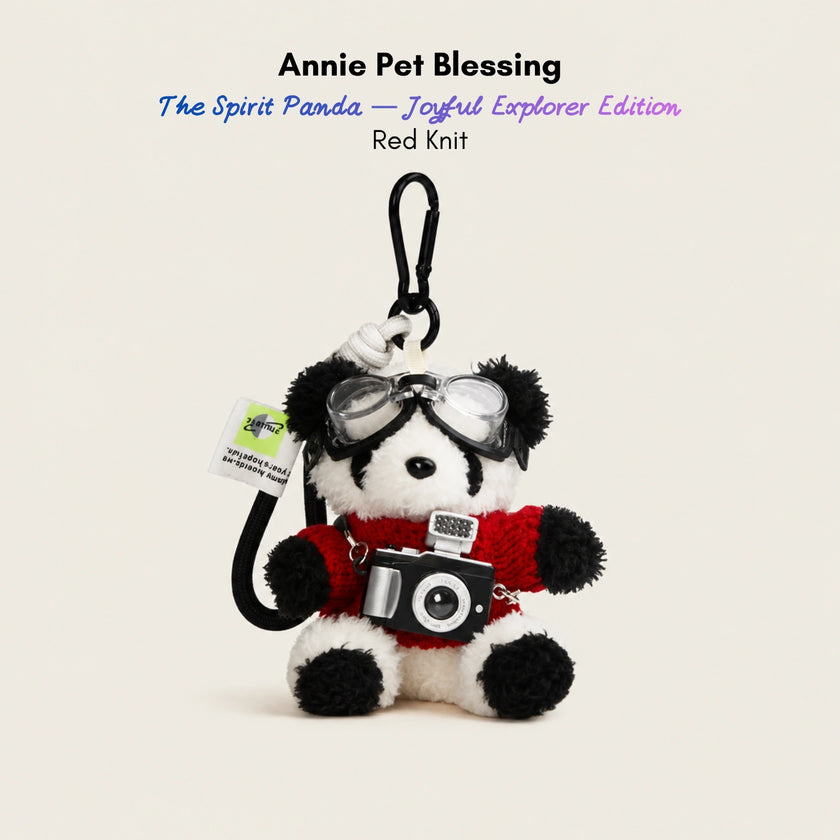 Plush Spirit Panda keychain wearing goggles and a red knit sweater, holding a toy camera