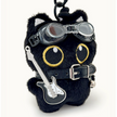 Close-up of a black plush Yoyo keychain wearing goggles, a studded collar, and a guitar-shaped charm