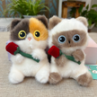 Calico and Siamese-style plush Spirit Cat keychains together, each holding a red rose