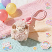 Pink plush Spirit Sheep keychain close-up on a pastel blanket with stickers