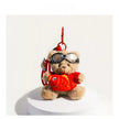 Tan plush Spirit Bear keychain wearing goggles, holding a red fish charm