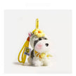 Close-up of a grey-and-white plush Spirit Dog keychain wearing a yellow crocheted flower headpiece