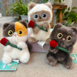 Three plush Spirit Cat keychains grouped together, each holding a red rose, indoor lifestyle setting