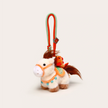 Close-up of a cream plush Heavenly Steed horse keychain with an orange bridle and bird charm