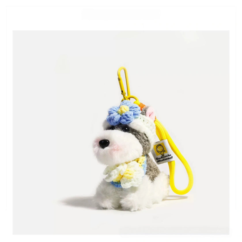 Close-up of a grey-and-white plush Spirit Dog keychain wearing a blue crocheted flower headpiece