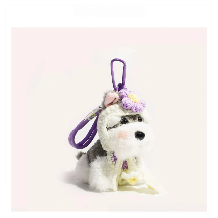 Close-up of a grey-and-white plush Spirit Dog keychain wearing a lavender crocheted flower headpiece