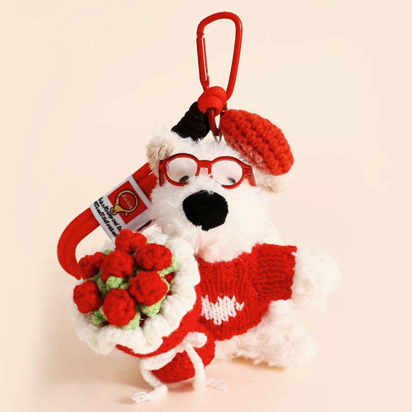 Westie plush keychain wearing a red sweater and beret, holding a crocheted red rose bouquet, lifestyle close-up