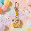 Yellow plush Spirit Sheep keychain resting on a pastel blanket with balloons and stickers