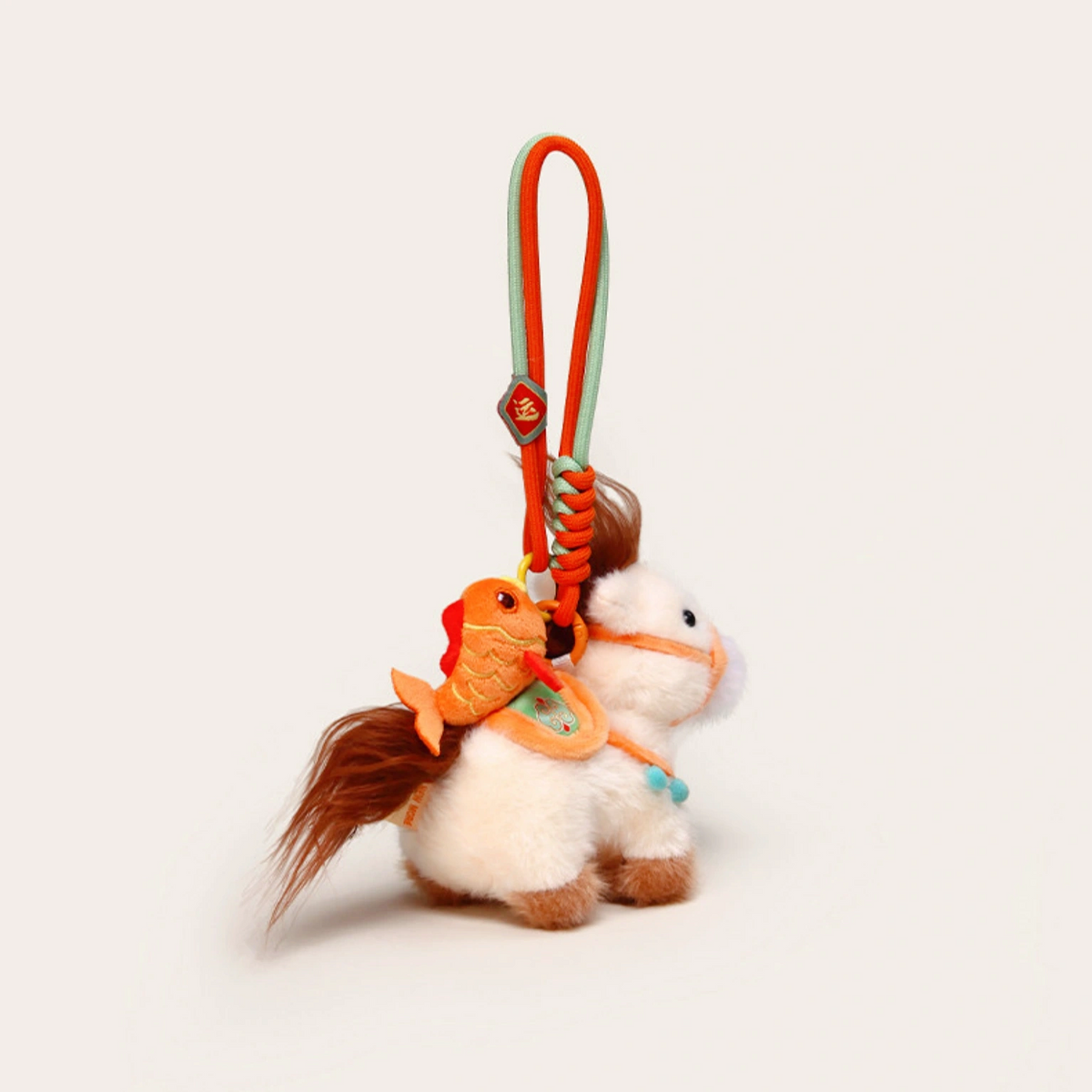 Close-up of a pink plush Heavenly Steed horse keychain with a red bridle and small charm