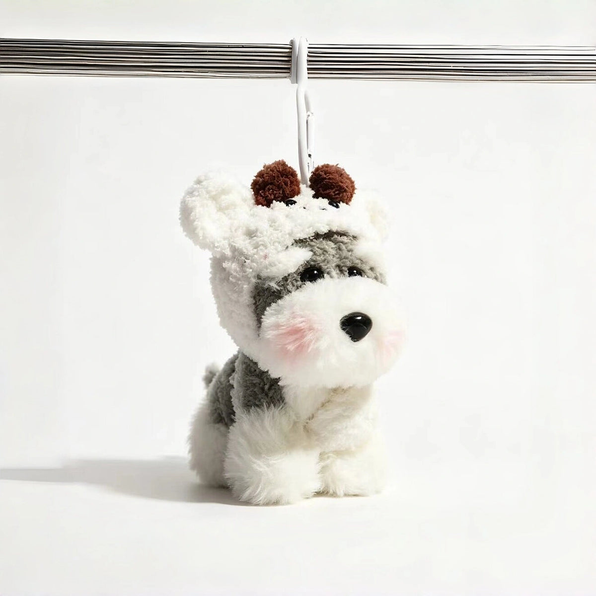 Grey-and-white plush Spirit Dog keychain wearing a white knitted hood with brown pom-pom ears