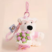 Westie plush keychain wearing a pink sweater and glasses, holding a pink-and-green crocheted flower bouquet