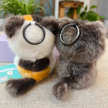 Rear view of two plush Spirit Cat keychains showing their ring keychain attachments